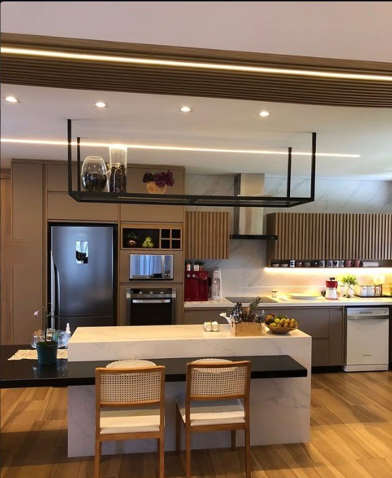 Cozinha com painel ripado sobre a bancada e faixa de luz embutida