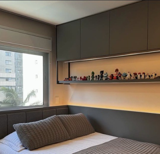 Quarto com cabeceira estofada, armários superiores e nicho com luz embutida