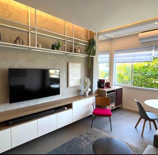 Painel de TV em madeira com bancada e nichos iluminados